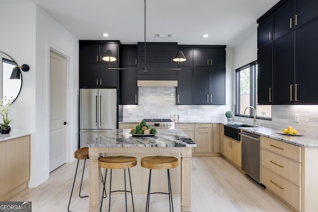 1962 8th St, Chamblee, GA 30341 - kitchen featuring appliances with stainless steel finishes, a sink, dark cabinetry, light brown cabinetry, and light wood-style floors