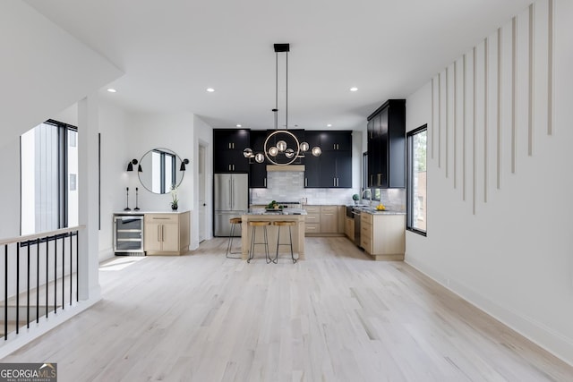 1962 8th St, Chamblee, GA 30341 - kitchen with beverage cooler, stainless steel appliances, dark cabinetry, light countertops, and backsplash