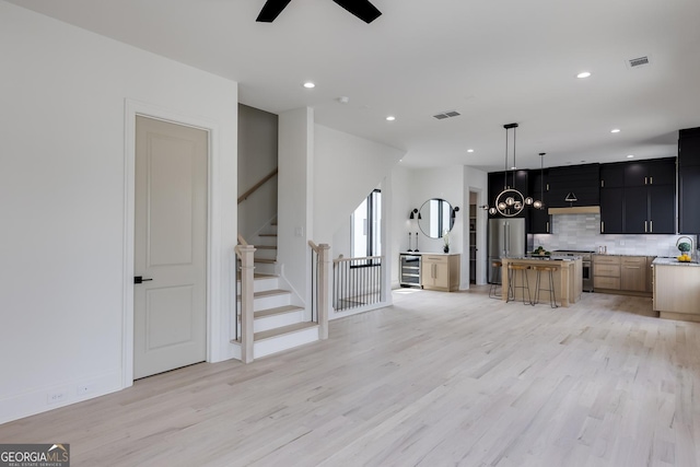 1962 8th St, Chamblee, GA 30341 - unfurnished living room featuring light wood-style floors, a ceiling fan, a chandelier, stairs, and recessed lighting