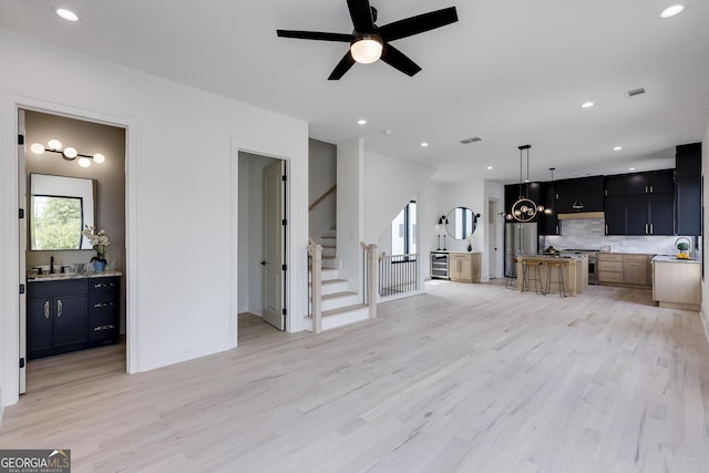 1962 8th St, Chamblee, GA 30341 - unfurnished living room featuring light wood-style floors, ceiling fan, stairs, a sink, and recessed lighting
