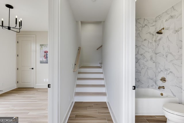 1962 8th St, Chamblee, GA 30341 - stairway featuring a chandelier, wood finished floors, and baseboards