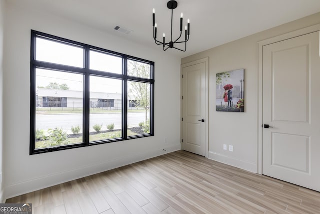 1962 8th St, Chamblee, GA 30341 - unfurnished bedroom featuring a chandelier, light wood-style flooring, and baseboards
