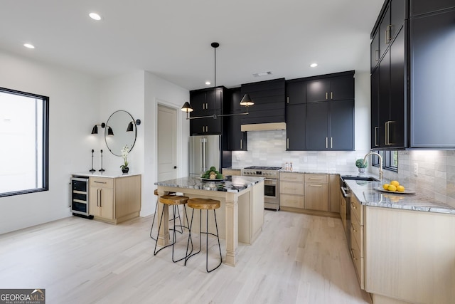 1962 8th St, Chamblee, GA 30341 - kitchen with premium appliances, wine cooler, a sink, dark cabinetry, and light wood-type flooring