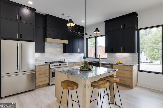 1962 8th St, Chamblee, GA 30341 - kitchen with appliances with stainless steel finishes, dark cabinets, a sink, a kitchen bar, and tasteful backsplash