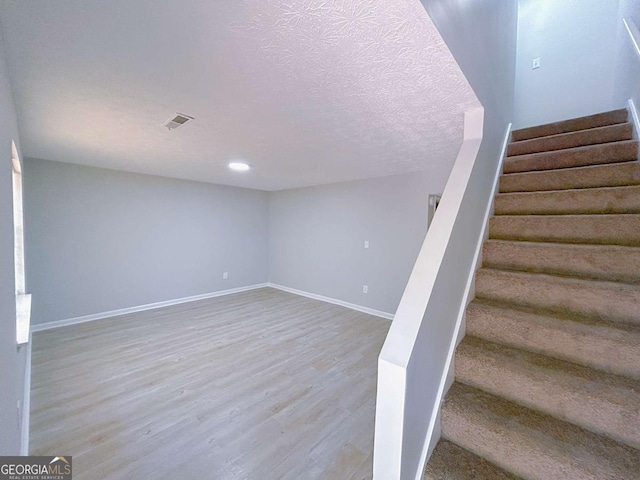 1820 Neely Ave, Atlanta, GA 30344 - stairway featuring wood finished floors, baseboards, and a textured ceiling