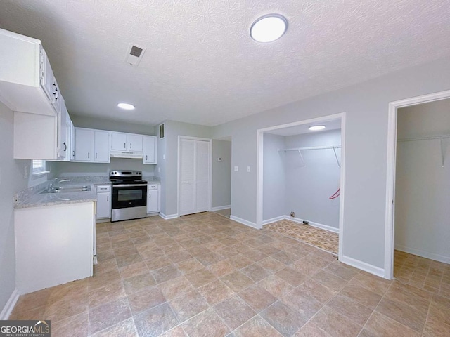 1820 Neely Ave, Atlanta, GA 30344 - kitchen with electric stove, under cabinet range hood, a sink, white cabinetry, and baseboards