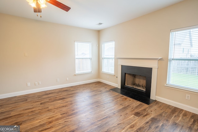 4135 Arch Pass, Cumming, GA 30040 - unfurnished living room featuring a fireplace with raised hearth, healthy amount of natural light, wood finished floors, and ceiling fan