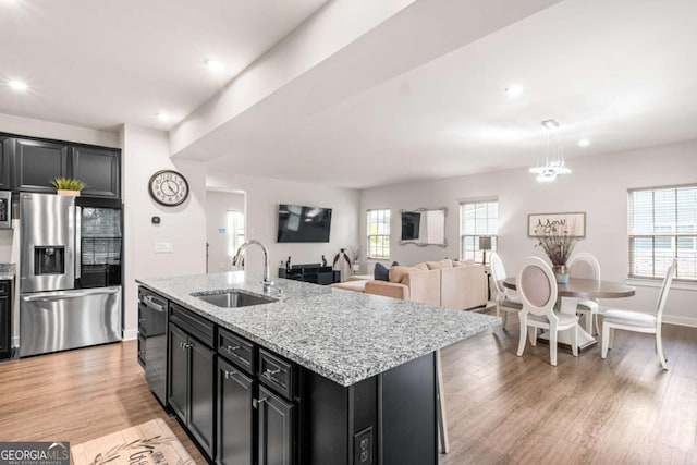 1049 Climbing Rose Way, Mcdonough, GA 30253 - kitchen featuring stainless steel fridge, a sink, dark cabinetry, dishwashing machine, and light wood-style floors