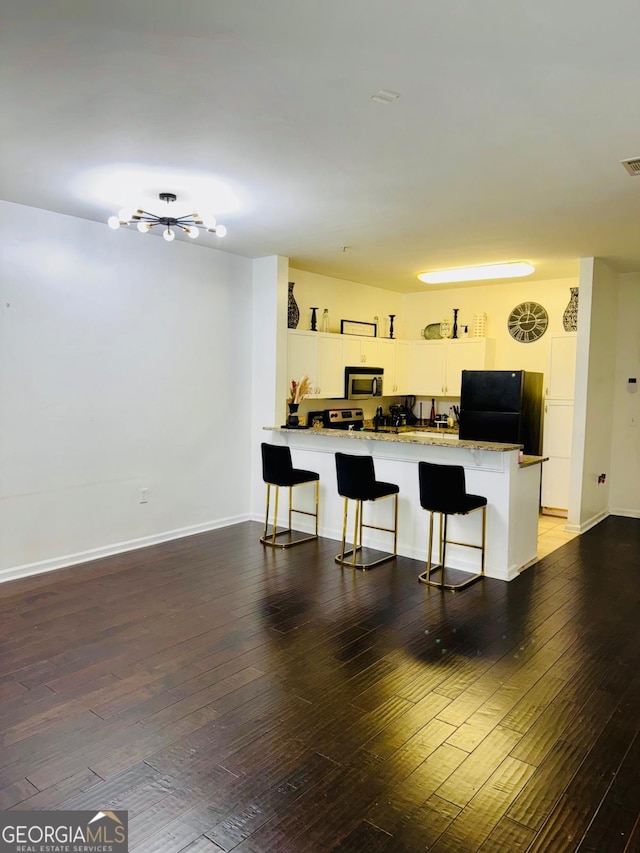 870 Mayson Turner Rd Unit 1207, Atlanta, GA 30314 - kitchen featuring freestanding refrigerator, a peninsula, a kitchen breakfast bar, hardwood / wood-style floors, and a desk