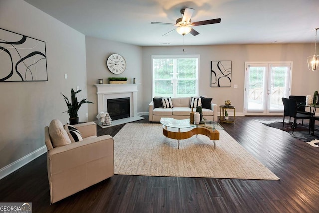 3557 Bryant Meadows Cir, Buford, GA 30519 - living area featuring ceiling fan, dark wood finished floors, baseboards, a glass covered fireplace, and a chandelier