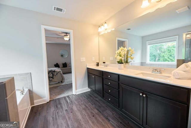 3557 Bryant Meadows Cir, Buford, GA 30519 - ensuite bathroom featuring double vanity, wood finished floors, a garden tub, baseboards, and ceiling fan