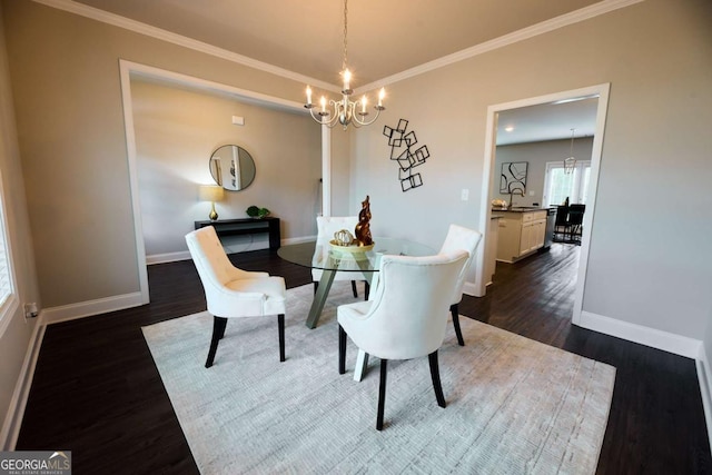 3557 Bryant Meadows Cir, Buford, GA 30519 - dining space featuring a chandelier, dark wood-style flooring, baseboards, and crown molding