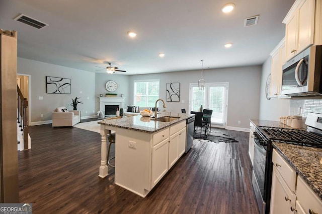 3557 Bryant Meadows Cir, Buford, GA 30519 - kitchen with stainless steel appliances, a sink, a fireplace, dark wood-style flooring, and recessed lighting