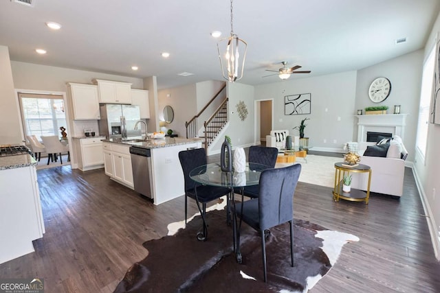3557 Bryant Meadows Cir, Buford, GA 30519 - dining room featuring stairway, dark wood-style floors, ceiling fan, a glass covered fireplace, and recessed lighting