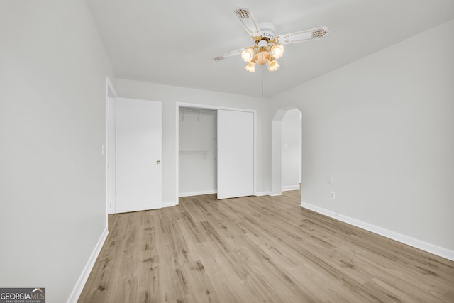 234 Edgewood Dr, Mount Airy, GA 30563 - unfurnished bedroom featuring wood finished floors, arched walkways, baseboards, a closet, and ceiling fan