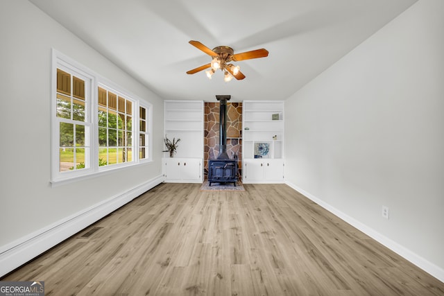 234 Edgewood Dr, Mount Airy, GA 30563 - unfurnished living room featuring a wood stove, baseboards, built in shelves, and a ceiling fan