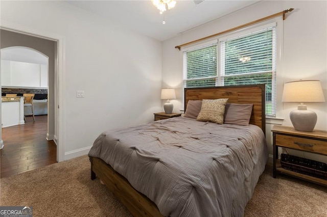 1055 Beacon Hill Xing, Alpharetta, GA 30005 - carpeted bedroom featuring wood finished floors, arched walkways, and baseboards