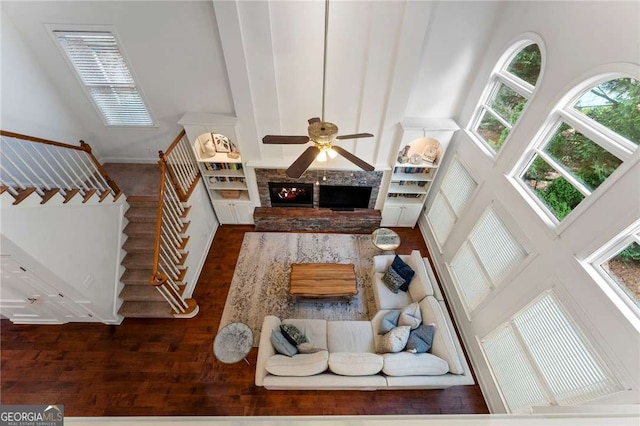 1055 Beacon Hill Xing, Alpharetta, GA 30005 - living room featuring a towering ceiling, wood finished floors, ceiling fan, a fireplace, and stairway