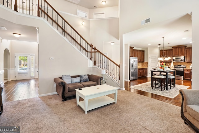 7946 White Oak Loop, Stonecrest, GA 30038 - living area with a towering ceiling, stairway, wood finished floors, and arched walkways