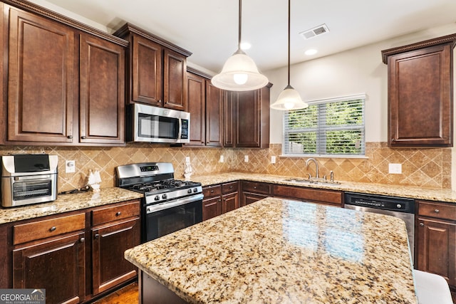 7946 White Oak Loop, Stonecrest, GA 30038 - kitchen featuring appliances with stainless steel finishes, light stone countertops, pendant lighting, and dark brown cabinetry