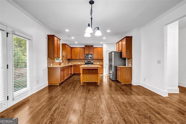7601 Watson Cir, Locust Grove, GA 30248 - kitchen featuring appliances with stainless steel finishes, a chandelier, light countertops, crown molding, and dark wood-type flooring