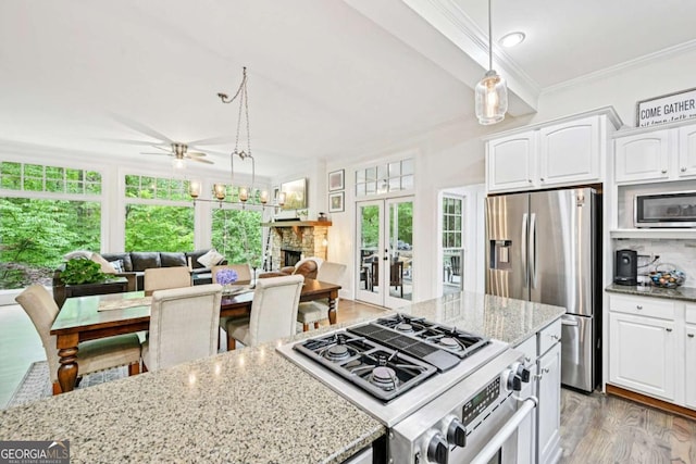 81 Cane Mill Ln, Dahlonega, GA 30533 - kitchen featuring appliances with stainless steel finishes, crown molding, healthy amount of natural light, a ceiling fan, and white cabinets
