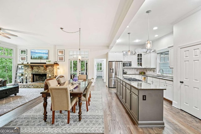 81 Cane Mill Ln, Dahlonega, GA 30533 - dining room with french doors, light wood-type flooring, ceiling fan, a stone fireplace, and ornamental molding