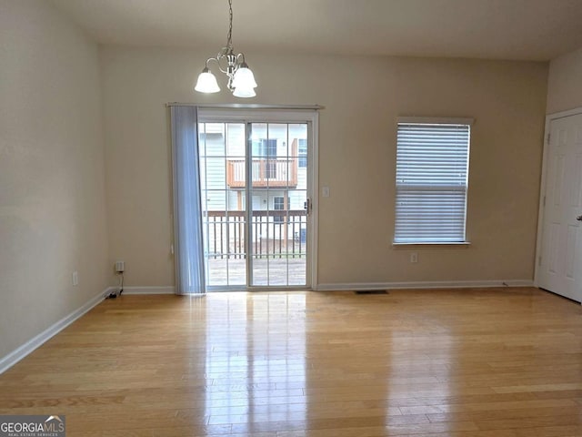 2104 Meadow Peak Rd, Duluth, GA 30097 - spare room featuring a chandelier and light wood-style flooring