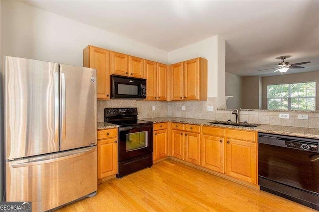 2104 Meadow Peak Rd, Duluth, GA 30097 - kitchen featuring black appliances, light wood finished floors, tasteful backsplash, and light stone counters