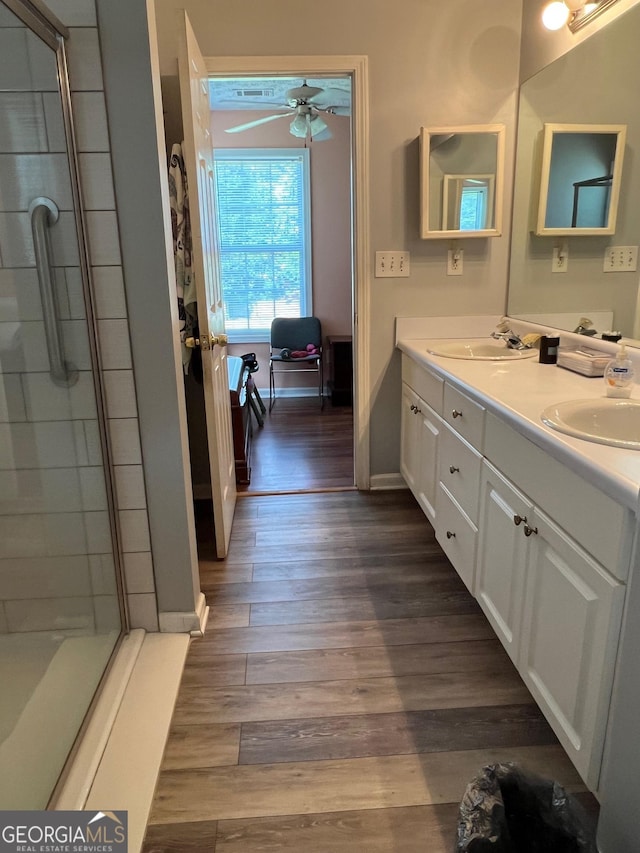 740 Pebble Blvd, Covington, GA 30016 - full bathroom with ceiling fan, double vanity, a shower stall, wood finished floors, and baseboards