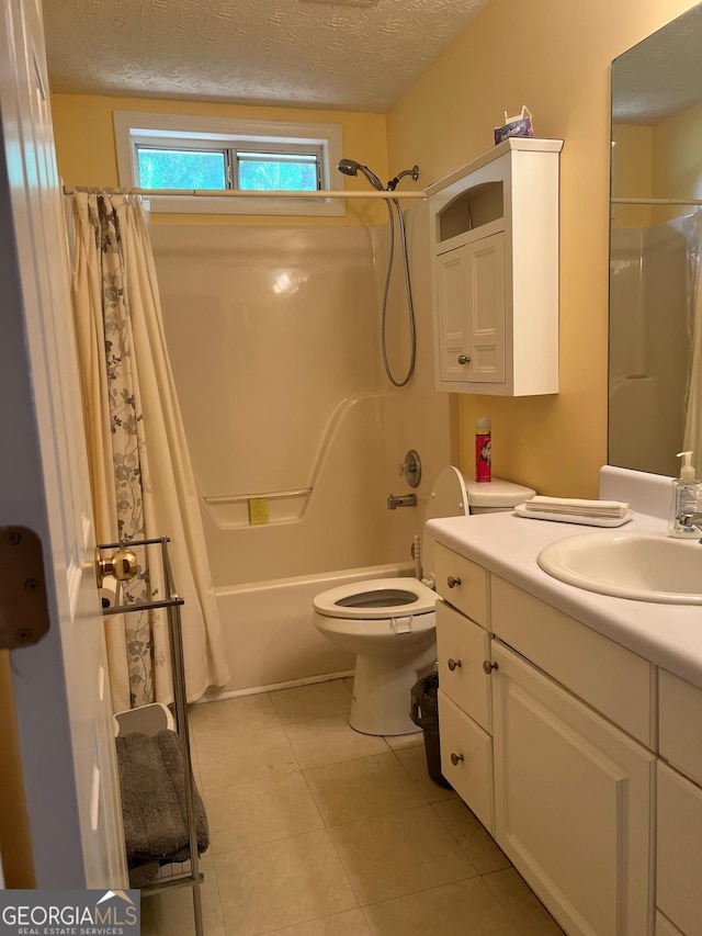 740 Pebble Blvd, Covington, GA 30016 - bathroom with vanity, shower / tub combo with curtain, a textured ceiling, tile patterned floors, and toilet