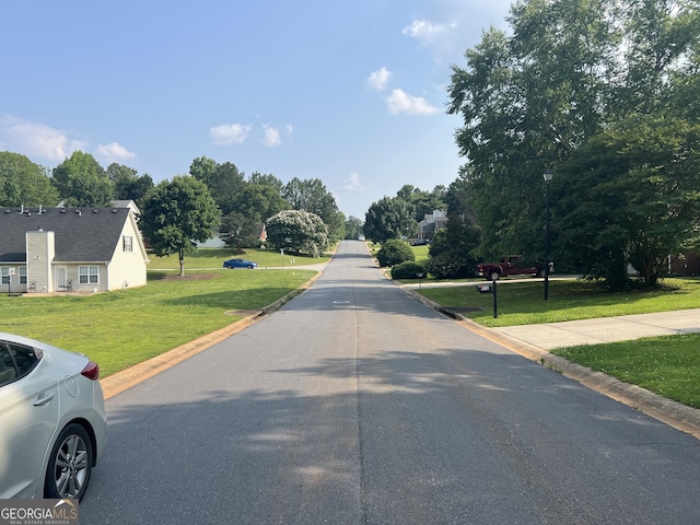 740 Pebble Blvd, Covington, GA 30016 - view of asphalt street featuring street lighting, curbs, and view of wooded area