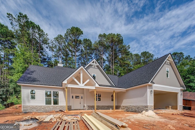 124 Flamingo Dr, Monticello, GA 31064 - view of front of home featuring stone siding, roof with shingles, a chimney, and a garage