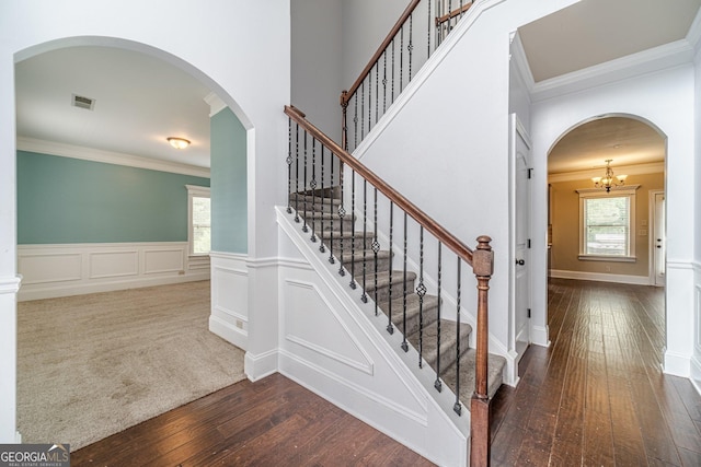 1022 Nestling Dr, Lawrenceville, GA 30045 - stairs with crown molding, hardwood / wood-style flooring, arched walkways, a wainscoted wall, and a decorative wall