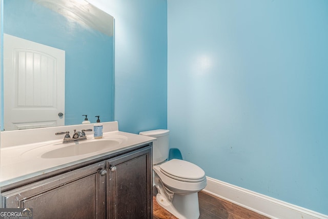 1022 Nestling Dr, Lawrenceville, GA 30045 - half bathroom featuring toilet, vanity, wood finished floors, and baseboards