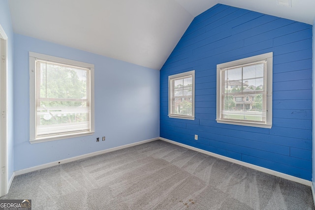 1022 Nestling Dr, Lawrenceville, GA 30045 - spare room featuring lofted ceiling, carpet, wood walls, and baseboards
