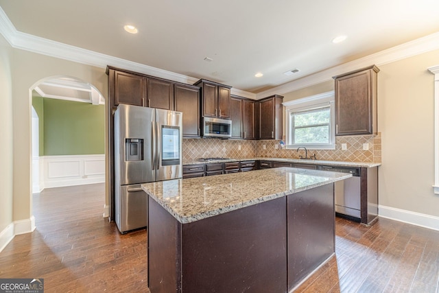 1022 Nestling Dr, Lawrenceville, GA 30045 - kitchen with stainless steel appliances, light stone countertops, ornamental molding, dark brown cabinets, and dark wood-style floors