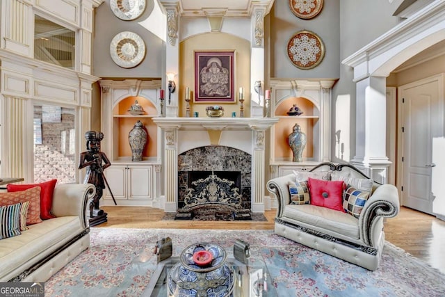 2279 Weeping Oak Dr, Braselton, GA 30517 - living room with wood finished floors, decorative columns, a fireplace, a towering ceiling, and built in shelves