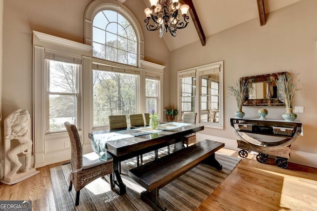 2279 Weeping Oak Dr, Braselton, GA 30517 - dining space featuring a chandelier, wood finished floors, high vaulted ceiling, and beamed ceiling