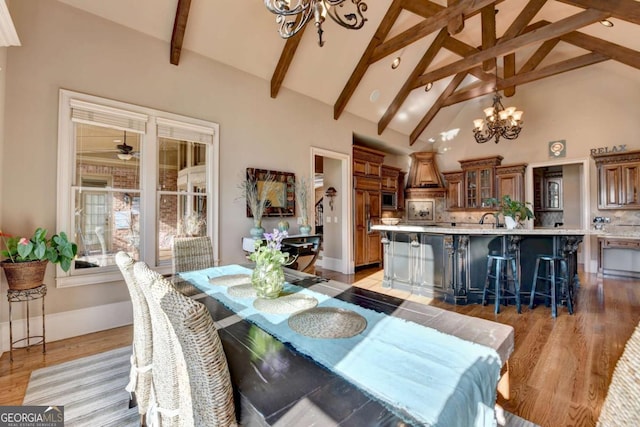 2279 Weeping Oak Dr, Braselton, GA 30517 - dining space featuring a chandelier, beamed ceiling, light wood-style floors, high vaulted ceiling, and baseboards