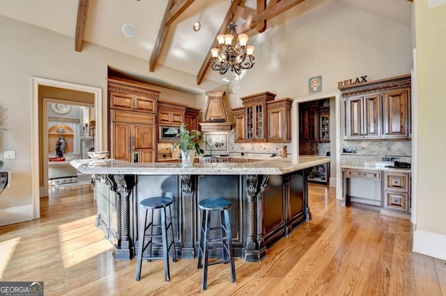 2279 Weeping Oak Dr, Braselton, GA 30517 - kitchen with built in appliances, a breakfast bar area, backsplash, brown cabinetry, and beam ceiling