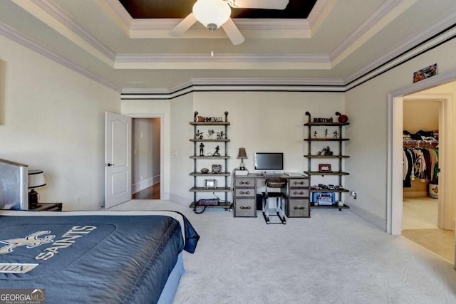 2279 Weeping Oak Dr, Braselton, GA 30517 - carpeted bedroom with a raised ceiling, crown molding, a walk in closet, a ceiling fan, and a desk