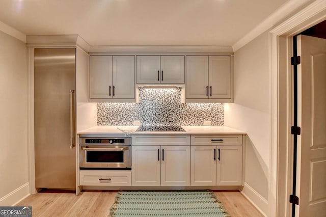 2279 Weeping Oak Dr, Braselton, GA 30517 - kitchen featuring stainless steel oven, light wood-style flooring, backsplash, and light countertops