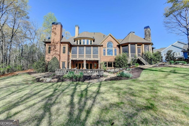 2279 Weeping Oak Dr, Braselton, GA 30517 - back of property with a sunroom, a chimney, a lawn, and stairs