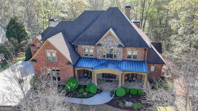 2279 Weeping Oak Dr, Braselton, GA 30517 - view of front of house with a chimney, brick siding, a standing seam roof, stone siding, and a patio