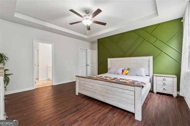 520 Edgemore Rd, Canton, GA 30114 - bedroom featuring a tray ceiling, wood finished floors, baseboards, ceiling fan, and a decorative wall