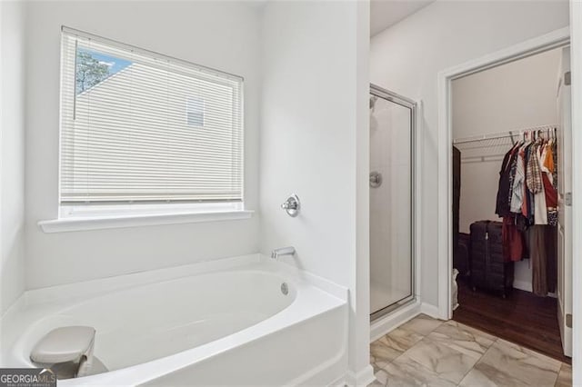 520 Edgemore Rd, Canton, GA 30114 - full bathroom featuring a bath, a shower stall, a walk in closet, and marble look tile flooring
