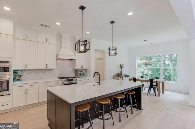5306 Weeping Creek Trl, Flowery Branch, GA 30542 - kitchen featuring custom exhaust hood, stainless steel appliances, decorative backsplash, white cabinets, and recessed lighting