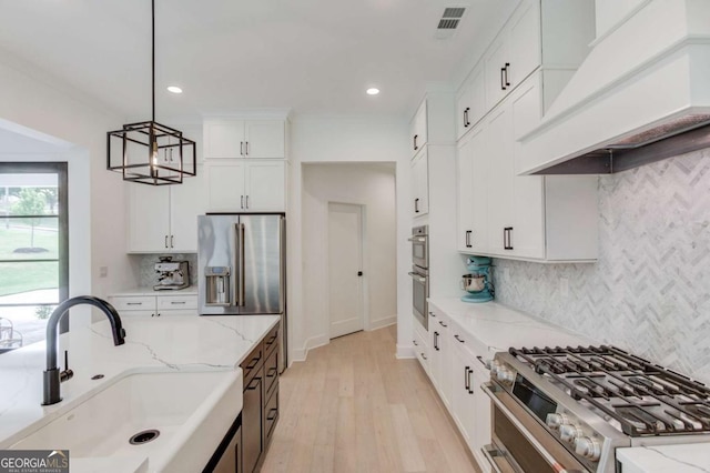 5306 Weeping Creek Trl, Flowery Branch, GA 30542 - kitchen featuring stainless steel appliances, a sink, premium range hood, white cabinets, and light wood-style flooring