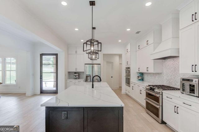 5306 Weeping Creek Trl, Flowery Branch, GA 30542 - kitchen featuring appliances with stainless steel finishes, light wood finished floors, recessed lighting, white cabinetry, and custom exhaust hood